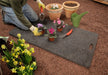 Man planting flowers on bedrug 2ft x 4ft folding utility mat trackmat for jeep wrangler off-road enthusiasts