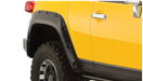 Close up of yellow truck with black tire, showcasing bushwacker pocket style fender flares for toyota fj cruiser