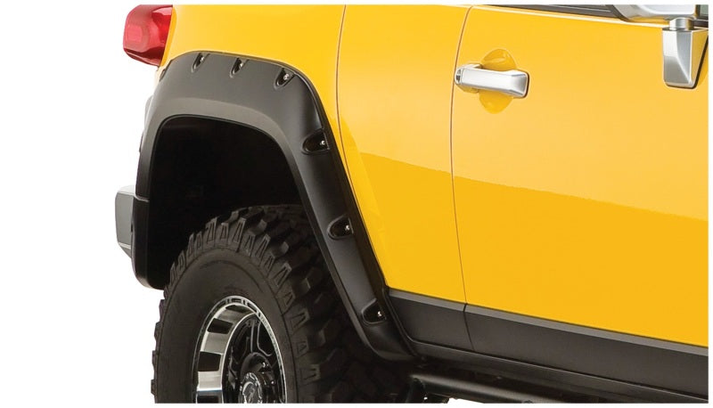 Close up of yellow truck with black tire, showcasing bushwacker pocket style fender flares for toyota fj cruiser