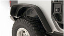 Close up of a truck with flat style fender flares and tire guard - bushwacker 07-18 jeep wrangler in black