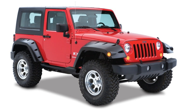 Red jeep wrangler with black pocket style fender flares and white wheels by bushwacker