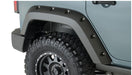 Close-up of bushwacker 07-18 jeep wrangler unlimited pocket style flares in black on a tire guard