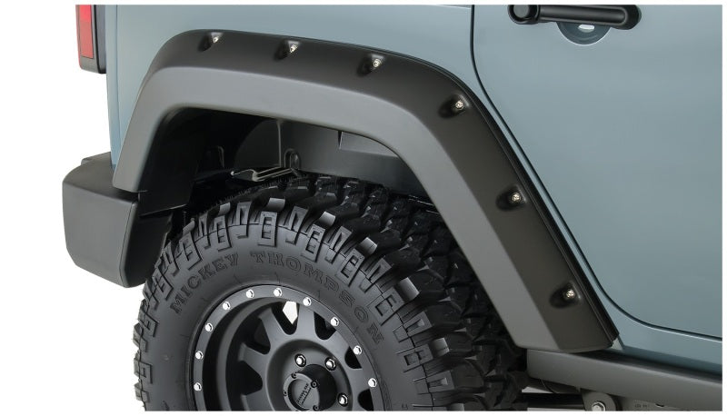 Close-up of bushwacker 07-18 jeep wrangler unlimited pocket style flares in black on a tire guard
