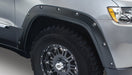 Front end view of gray truck with bushwacker pocket style flares for jeep grand cherokee in black