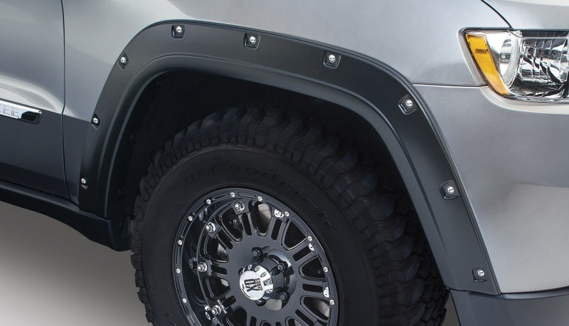 Front end view of gray truck with bushwacker pocket style flares for jeep grand cherokee in black