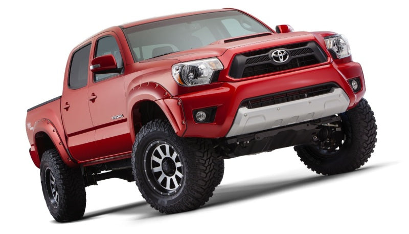 Red toyota tacoma truck with pocket style fender flares on white background