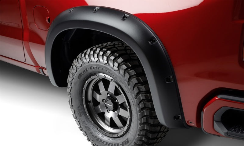 Red truck with black tire cover featuring bushwacker forge style flares for toyota tacoma