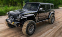 Jeep wrangler driving down dirt road in woods with hyperform fender flares - black