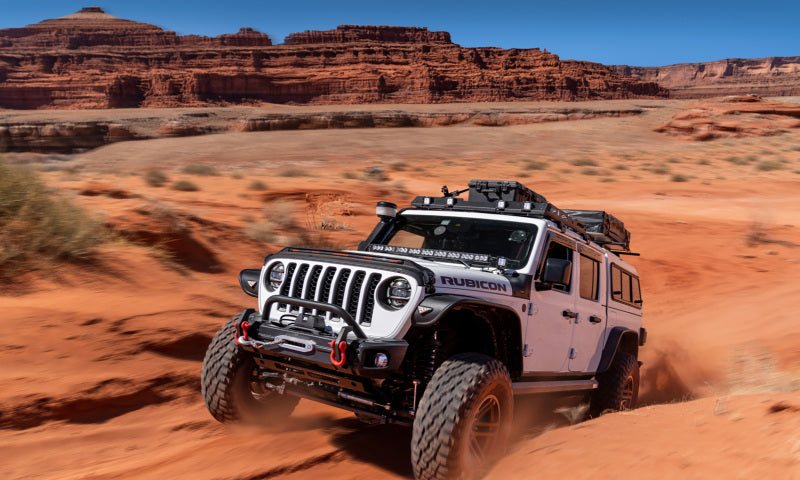 White jeep gladiator driving through desert with bushwacker trail armor rocker panel