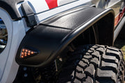 White truck with red and white stripe displayed on bushwacker 2020 jeep gladiator flat style fender flares