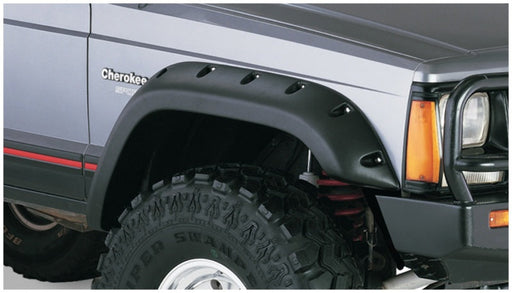 Black jeep cherokee with bushwacker fender flares and large tire guard on a product display