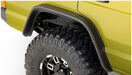 Yellow truck with black tire cover next to bushwacker 84-01 jeep cherokee flat style fender flares