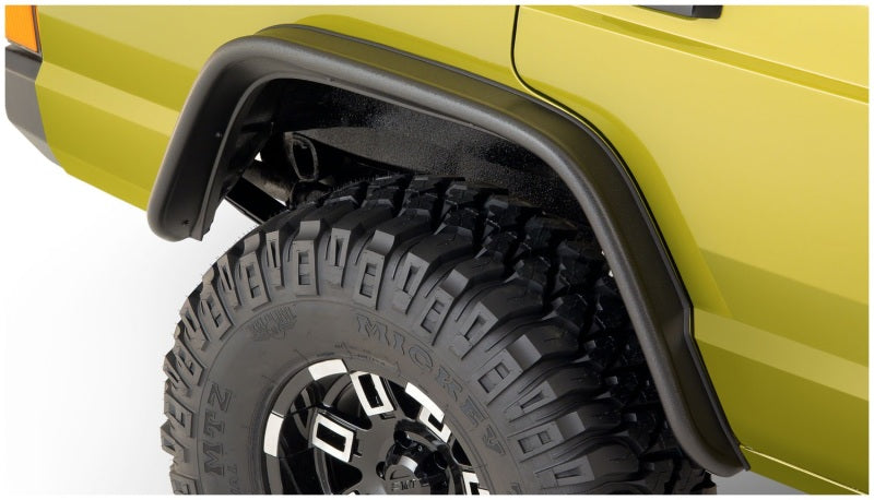 Yellow truck with black tire cover next to bushwacker 84-01 jeep cherokee flat style fender flares