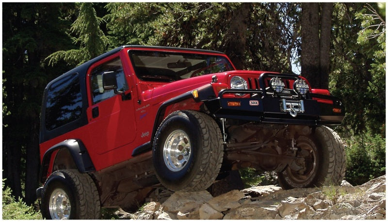 Black pocket style fender flares on red jeep wrangler driving rocky trail