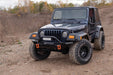 Jeep wrangler with trail armor hood stone guard parked on dirt road