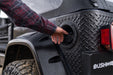 Man installing tire on jeep wrangler with bushwacker trail armor rear corners