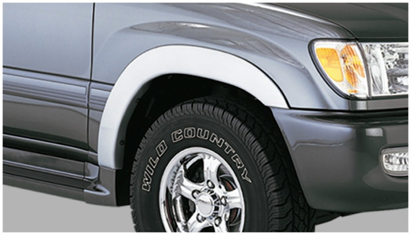 Black bushwacker fender flares on toyota land cruiser with white tire cover