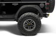 Black jeep wrangler jl with bushwacker trail armor fender delete kit and black tire cover