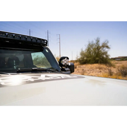 White truck with black roof rack showcasing DV8 21-22 Ford Bronco A-Pillar Pod Light Mounts.
