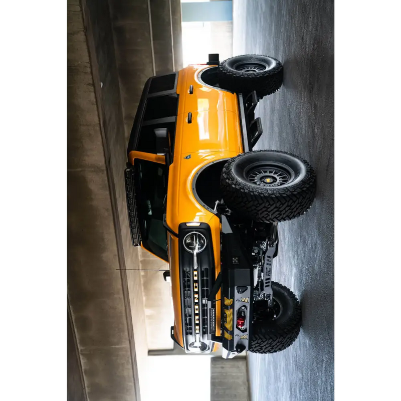 Yellow Ford Bronco light bracket with black tire and wheels