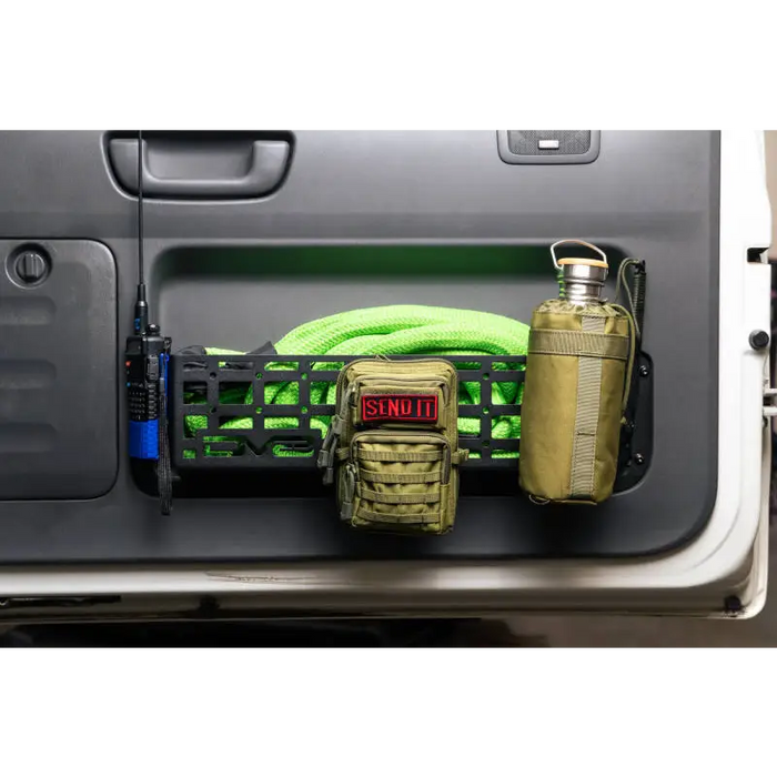 Green hose and water bottle in the back of a truck with DV8 Offroad 03-09 Lexus GX 470 Molle Door Pocket.