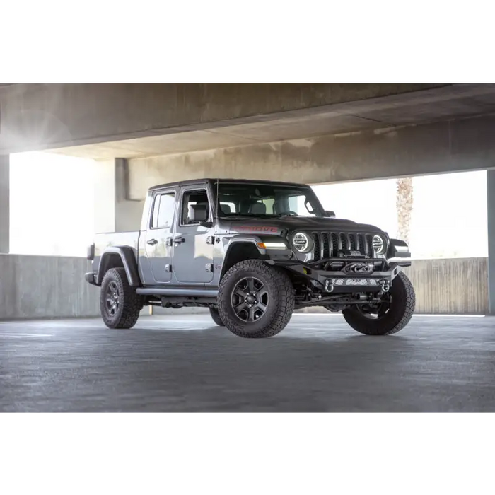 Black jeep parked in garage, dv8 offroad mto series front bumper for jeep wrangler.