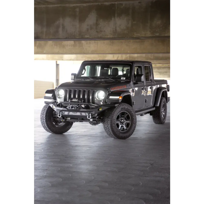 Black jeep parked in parking garage next to dv8 offroad mto series front bumper.