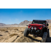 Red Jeep parked in desert with DV8 Offroad rear flat tube fenders.