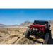 Red Jeep parked in desert with DV8 Offroad rear flat tube fenders.