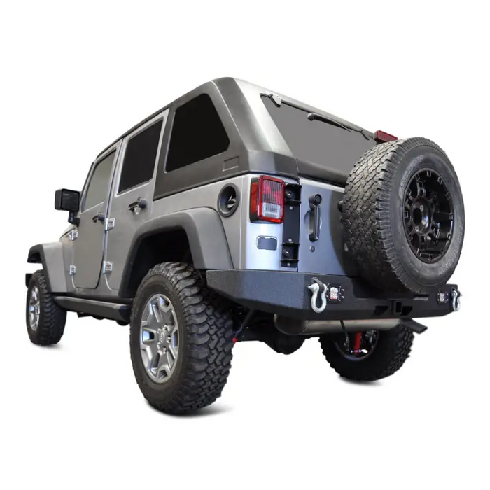 DV8 Offroad Jeep Wrangler JK Full Length Rear Bumper with large tire on white background