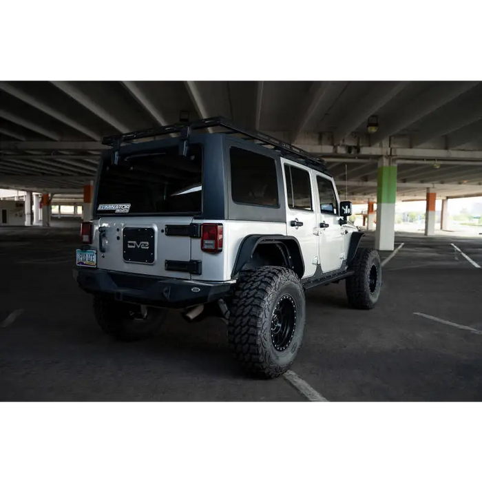 White jeep parked in lot next to DV8 Offroad roof rack for Jeep Wrangler.