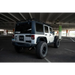 White jeep parked in lot next to DV8 Offroad roof rack for Jeep Wrangler.