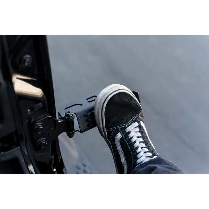 Black sneakers and jeans worn by person with DV8 Offroad foot pegs on Jeep Gladiator/Wrangler.