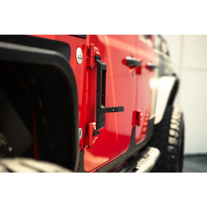 Red Jeep with black bumper and tire in DV8 Offroad 07-23 Jeep Gladiator/Wrangler hinge mounted step