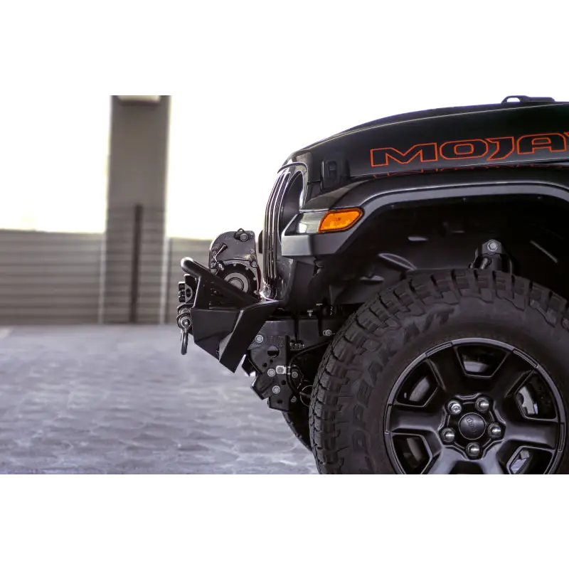 DV8 Offroad black Jeep Wrangler front bumper with red decal.