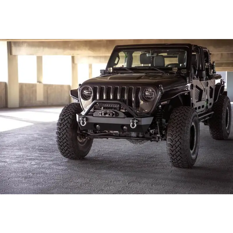 DV8 Offroad front bumper with bull bar on a parked Jeep Wrangler in parking garage with large window