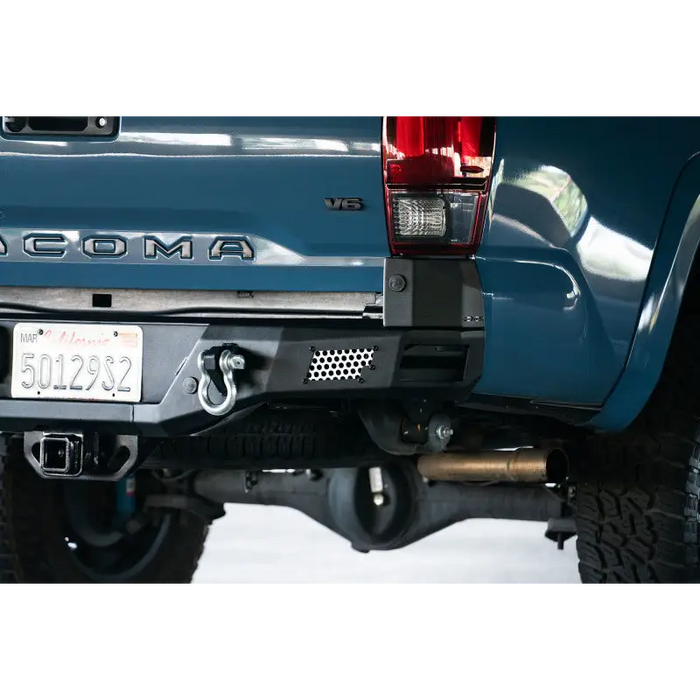 Blue truck with license plate on DV8 Offroad 16-23 Toyota Tacoma MTO Series Rear Bumper