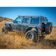 Gray Jeep Wrangler JL 4-Door with Roof Rack parked in field under blue sky
