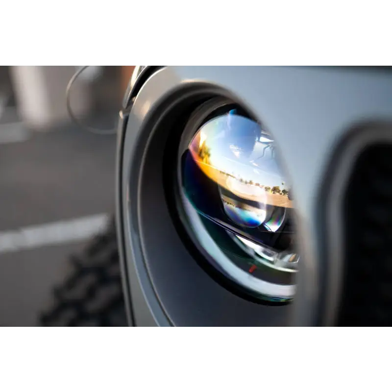 DV8 Offroad LED Headlights with camera lens reflection of building in the background.