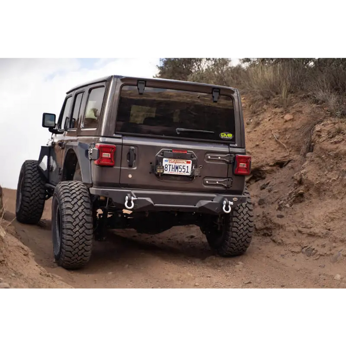 Jeep Wrangler driving down steep hill with spare tire delete kit.