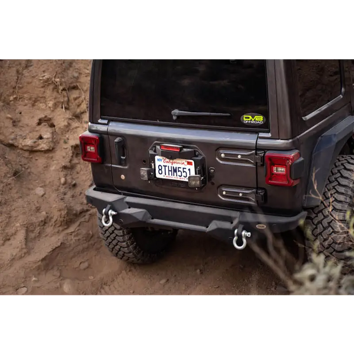 DV8 Offroad Jeep Wrangler JL Spare Tire Delete Kit parked on a dirt road