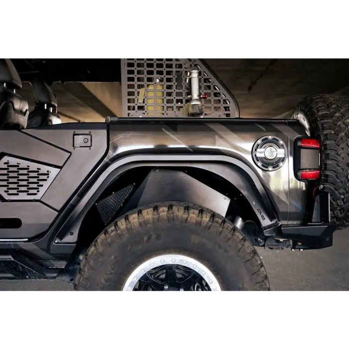 Black Jeep with large tire parked in garage, showcasing DV8 Offroad slim fender flares.