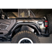 Black Jeep with large tire parked in garage, showcasing DV8 Offroad slim fender flares.