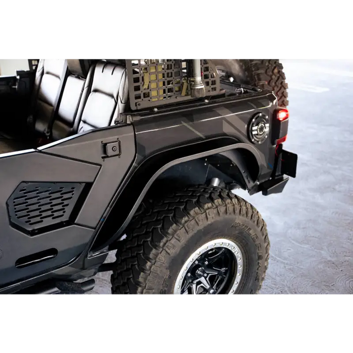 Black Jeep with large tire and rack on back, showcasing DV8 Offroad Slim Fender Flares.