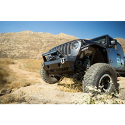 Jeep parked on rocky trail with sway bar disconnect motor skid plate.