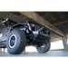 Black Jeep Wrangler JL/JT with large tire, featuring DV8 Offroad Front Bumper Sway Bar Disconnect Motor Skid Plate