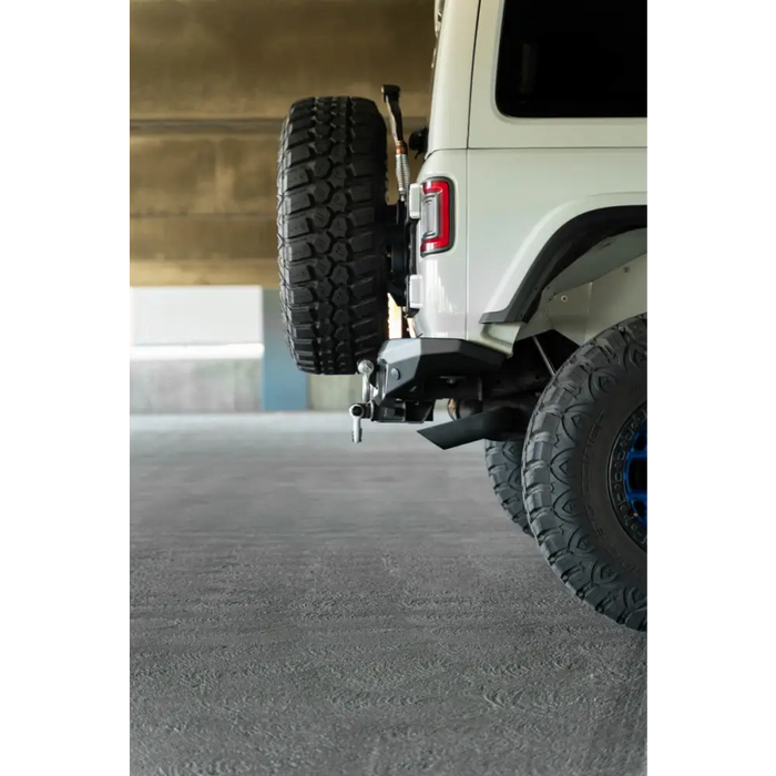 White truck with tire cover attached to DV8 Offroad FS-7 Series Rear Bumper