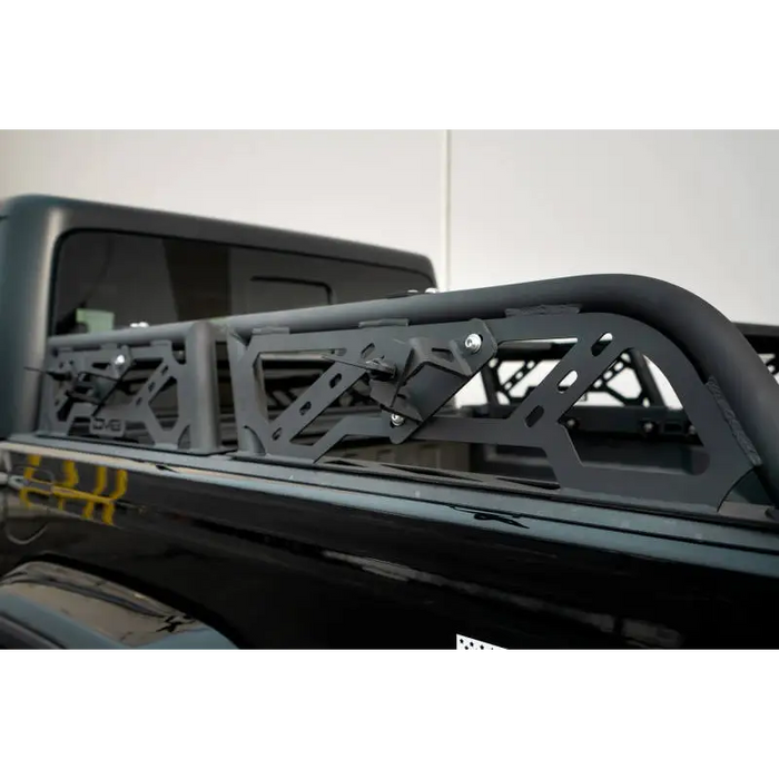 DV8 Offroad adjustable bed rack for overland Toyota Tacoma with black jeep and roof rack.