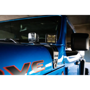 Blue truck with white and red stripe dual pod light mounts.