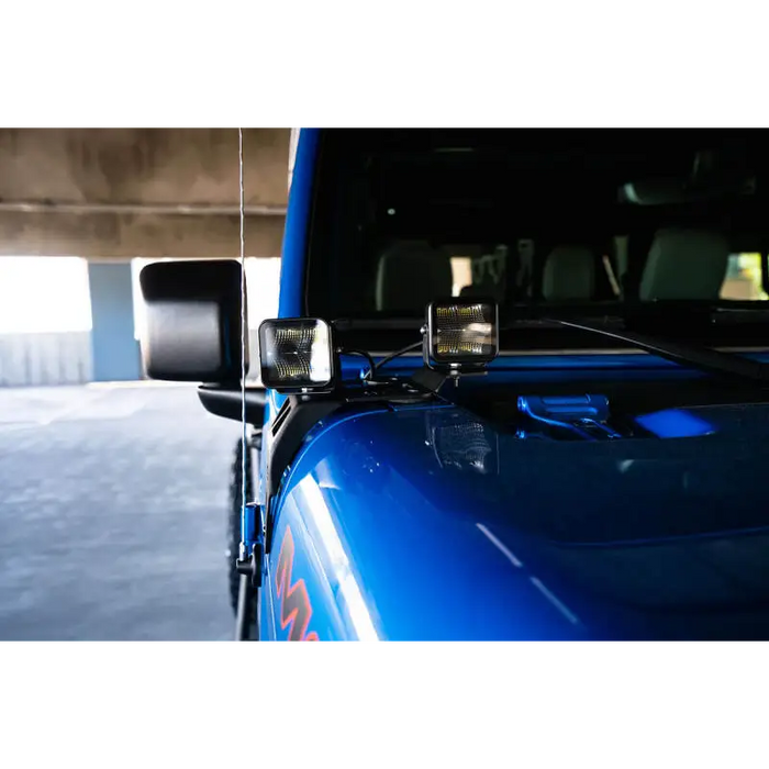Blue car with side mirror displayed in DV8 Offroad 20-22 Jeep JL 392/Jeep JT Mojave Edition Dual Pod Light Mounts.